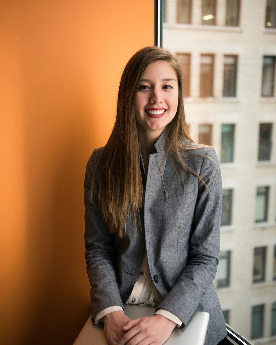 Empreendedora sorrindo encostada na janela do escritório